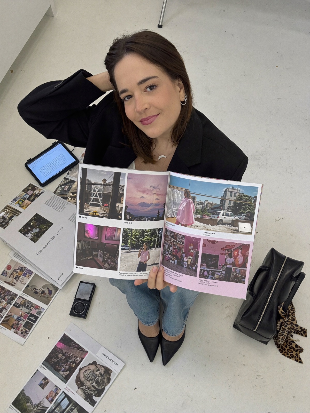 domi sentada no chão, vista de cima, segurando uma revista de posts